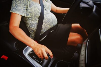 A woman driving a car and wondering, “What if I’m involved in a low-impact car accident during pregnancy?”