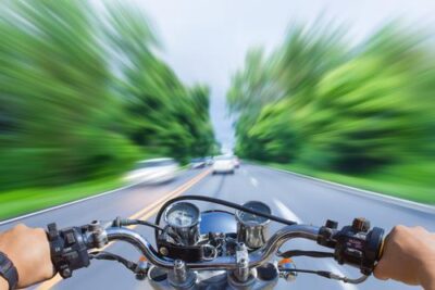 A damaged motorcycle lies on the road after a collision with a car. A personal injury lawyer can tell you more about how motorcycle accidents are different than car accidents.