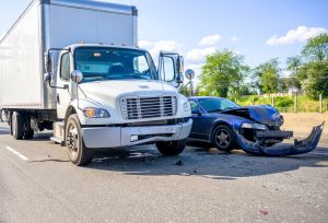 A truck is stopped next to a wrecked car