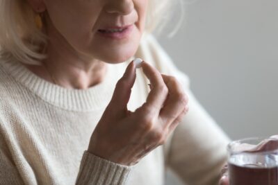 A concerned middle aged woman takes a prescription drug