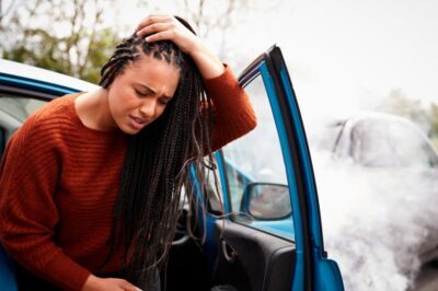 A woman holds her injured head after a car accident