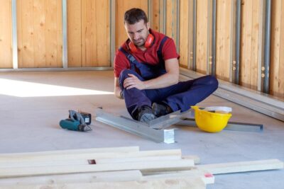 Construction worker clutches knee after injury