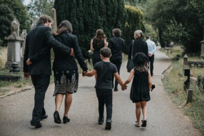 Grieving family walking through cemetery