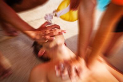 Two lifeguards resuscitating boy after drowning in pool