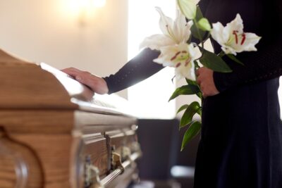 Woman holds flowers coffin