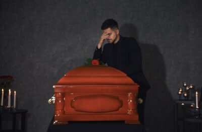 Sad young man at a casket