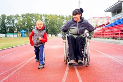 Woman in wheelchair and child race on track 1