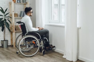 Man sitting in a wheelchair by the window