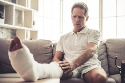 Man touching his broken leg in a cast