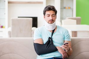 Man with neck injury looks at phone