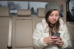 Backseat rideshare passenger listens to music