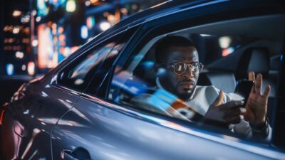 Man rides in back seat of car at night