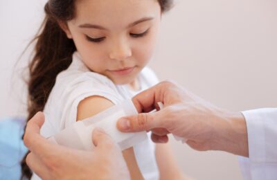 Doctor bandaging a childs shoulder