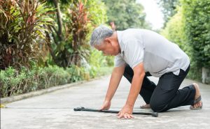 Elderly man falling on sidewalk