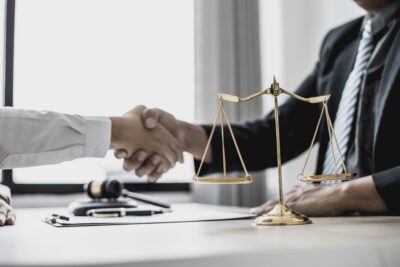 Worker shakes hands with comp lawyer. Learn when you should hire a lawyer for your workers' compensation claim.