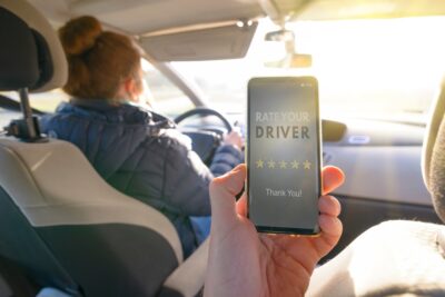 Passenger in a rideshare using a phone