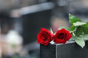 Red roses on black granite tombstone