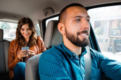 Smiling driver talking to a female passenger