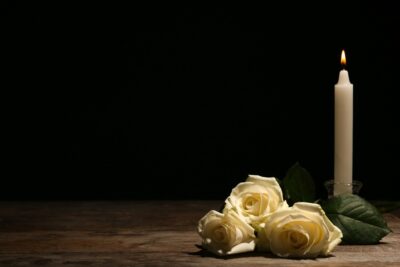 White roses and candle on table