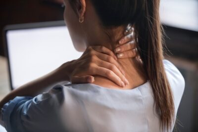 Woman holding neck in pain