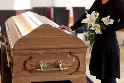 Woman in mourning touching a coffin