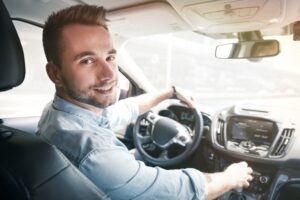 Young male driver behind the wheel of a rideshare