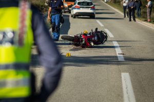 Accident scene with downed motorcycle and first responders