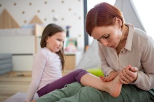 Mother inspecting daughters foot