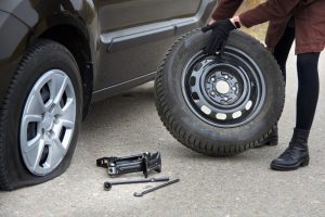 Woman changing tire after accident