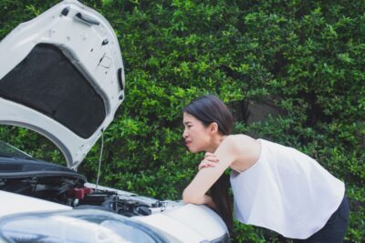 Woman checking out car accident damage