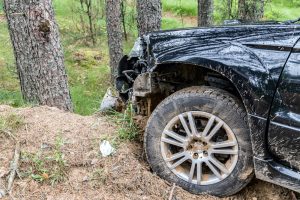 Crashed black car on hill