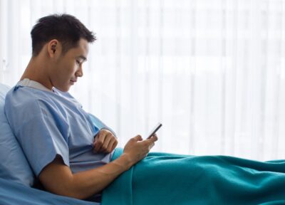 Injured man uses phone in hospital