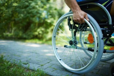 Close up on person pushing a wheelchair