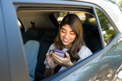 Woman on her phone in rideshare scaled