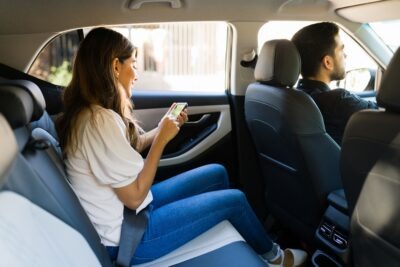 Woman sitting in the back of a rideshare car scaled