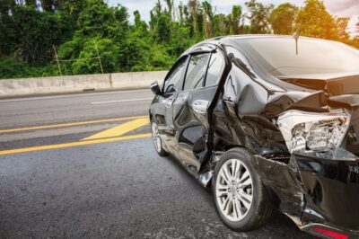 Smashed up black car from the side