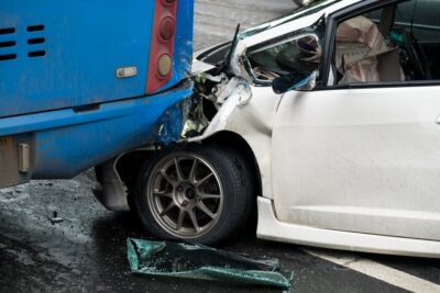 White car in a bus accident