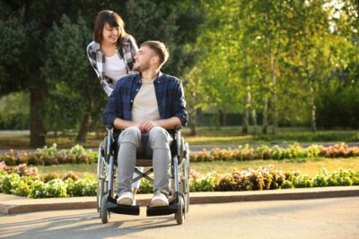 Woman pushing man in a wheelchair