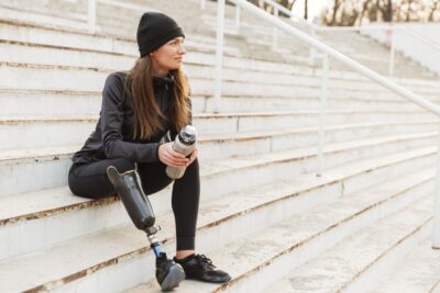 Woman sitting on steps with a prosthetic leg