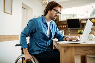 Young disabled businessman using laptop