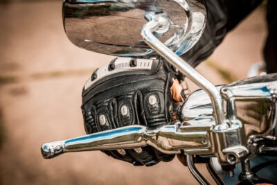 Close up on racing glove on motorcycle handle scaled