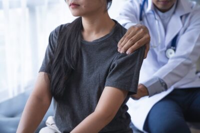 Doctor helping patient with lower back pain