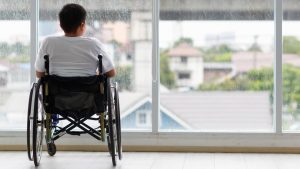 Man in wheelchair looking out window