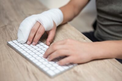 Man with broken fingers typing