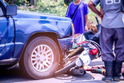 Motorcycle with blue pickup in crash