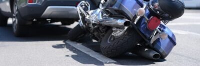 Close up on motorcycle trapped under car scaled