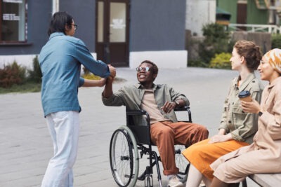 Black man in wheelchair greeting family scaled