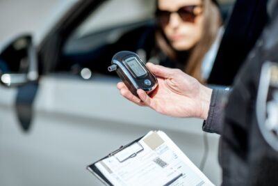 Cop checking breathalyzer for drunk driver