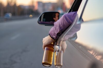 Man driving with a bottle in his hand