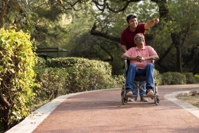 Man pushing other man in wheelchair